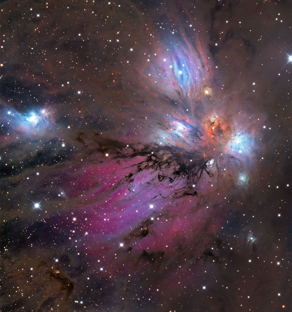 A starfield surrounds a colorful nebula that
glows both red and blue but is filled with dust, both 
light brown and dark brown. 
Please see the explanation for more detailed information.