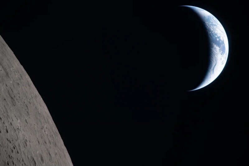 A crescent Earth rises above the dark horizon of the Moon, with the Moon's rocky surface visible in the foreground and the blackness of space surrounding both.