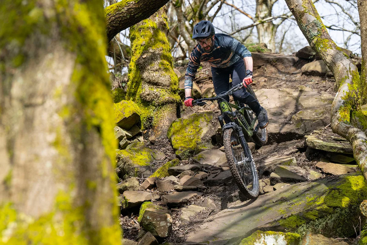 Male rider in blue top riding the Cube Stereo ONE77 C:68X TM 29 full suspension mountain bike