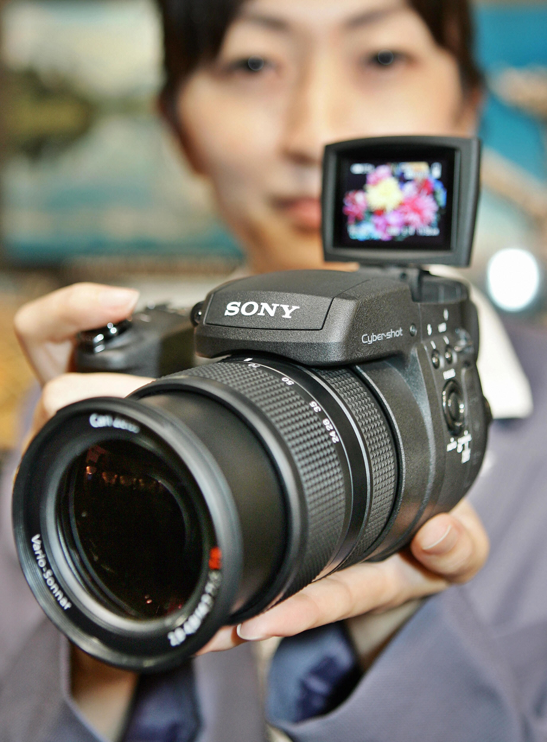 Sony employee displays the company's flagship digital camera Cybershot DSC-R1;, equipped with a large sized 10.8 megapixel CMOS image sensor (R) and a 4.8 Carl Zeiss Verio-Sonnar zoom lens
