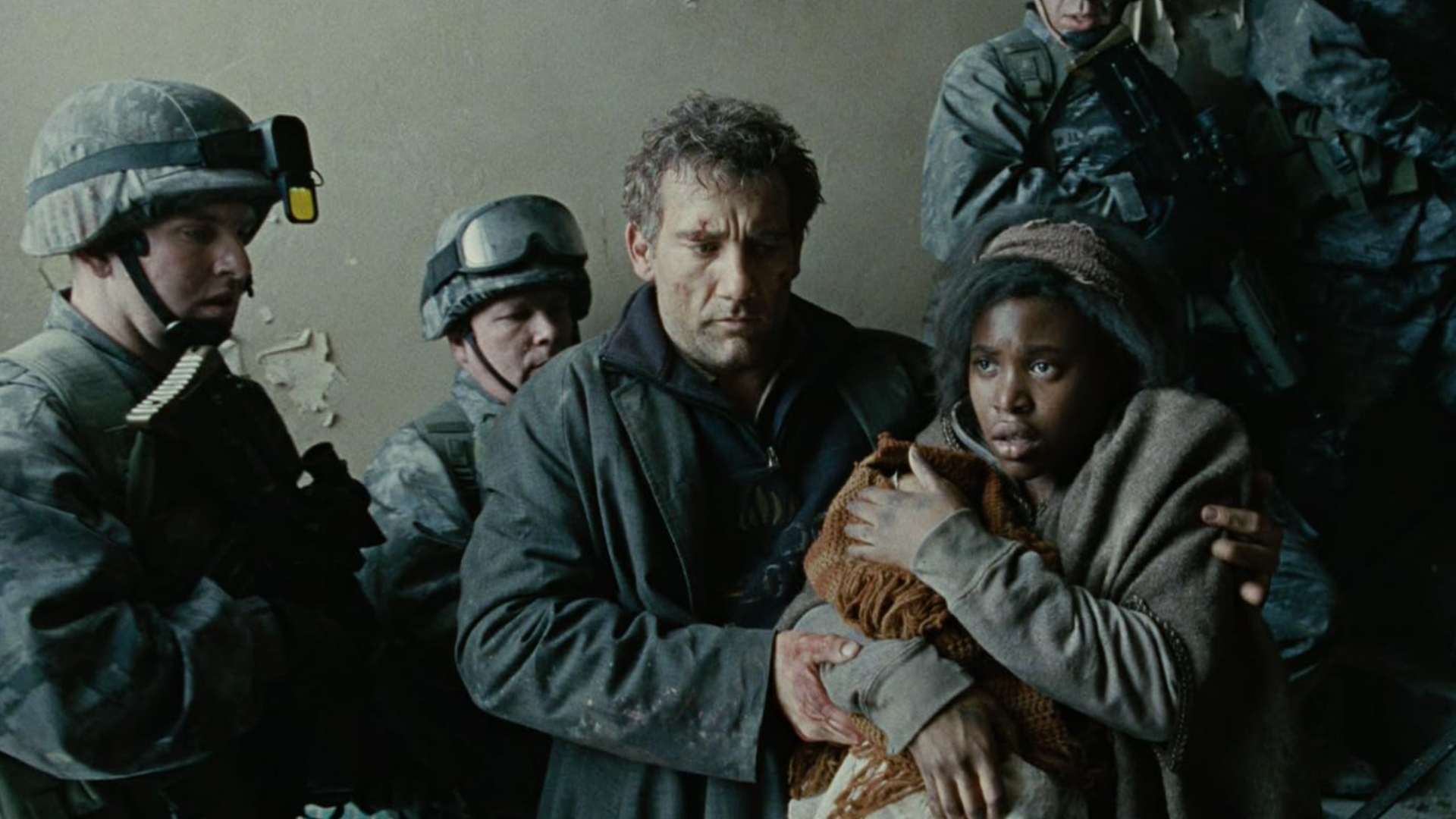 A woman shielding a baby huddles close to a man who has rugged clothes and scuffed clothes, surrounded by soldiers.