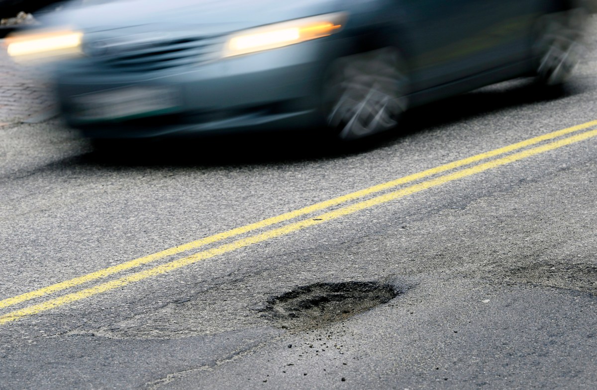 CAPE ELIZABETH, ME - FEBRUARY 22: A car drives past a pothole on Forest Ave. in Portland Tuesday, February 22, 2022. (Shawn Patrick Ouellette/Portland Press Herald via Getty Images)