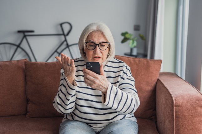 Frustrated mature woman struggling with smartphone technology