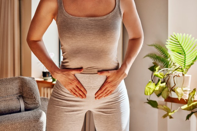 Woman experiencing painful cramps holding her abdomen