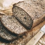 Home-baked wholemeal glutenfree bread and bread knife on brown paper - stock photo