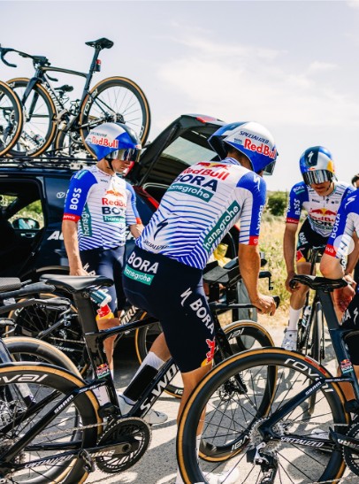 Red Bull Bora Hansgrohe riders stopped in front of a team car during team time trial training