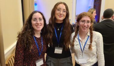 Sam (center) and Phoebe (right) are a part of HIAS+JCORE's Student Refugee Ambassador Program (SRAP). They joined refugee supporters at an event to launch Refugee Shabbat in London on March 12, 2026 (Jennie van den Boogaard/HIAS).