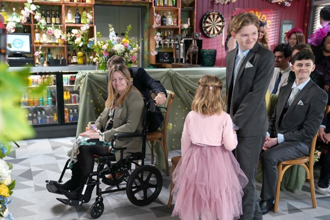 Diane in her wheelchair as Eva arrives with Ro in Hollyoaks
