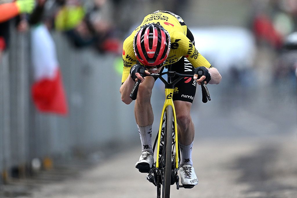 Vingegaard kisses a photo of his family on his handlebars after winning the stage