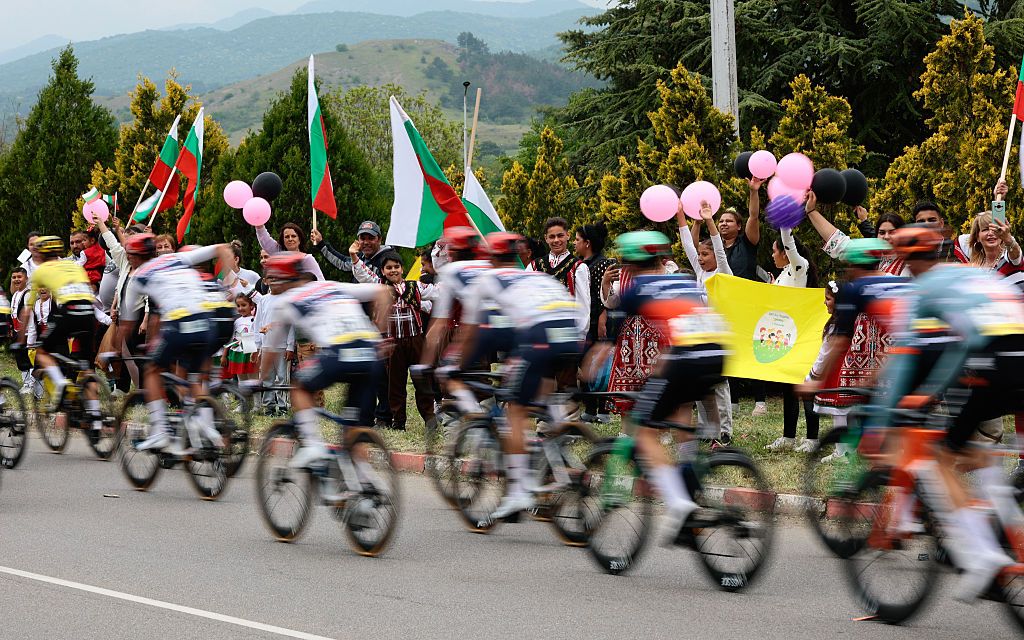 Spectators waving Bulgarian national flags as the pack of rides compete during the 2nd stage of the Giro d'Italia 2026 - Tour of Italy cycling race between Burgas and Veliko Tarnovo, Bulgaria, on May 9, 2026. (Photo by Luca Bettini / AFP)