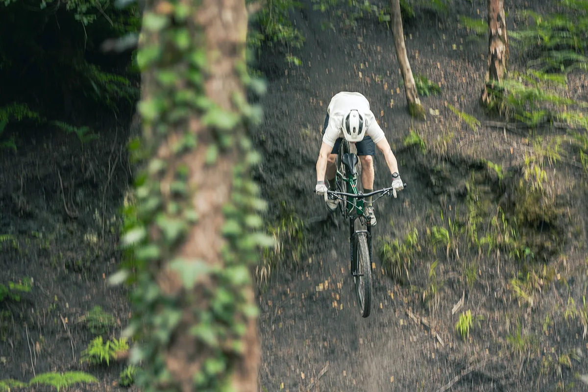 Male rider in white top riding the Merida Big.Trail 600 hardtail mountain bike