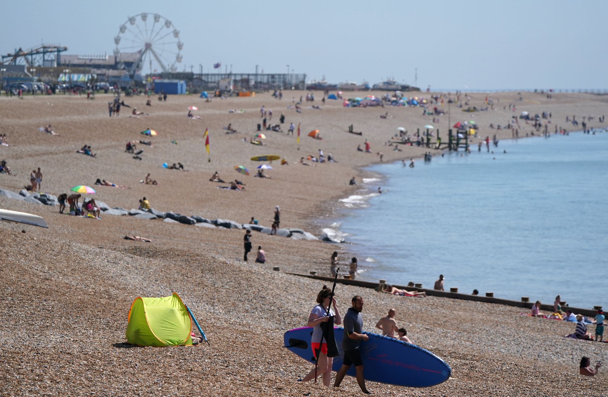 People enjoy the warm weather on Hastings beach in East Sussex in 2021