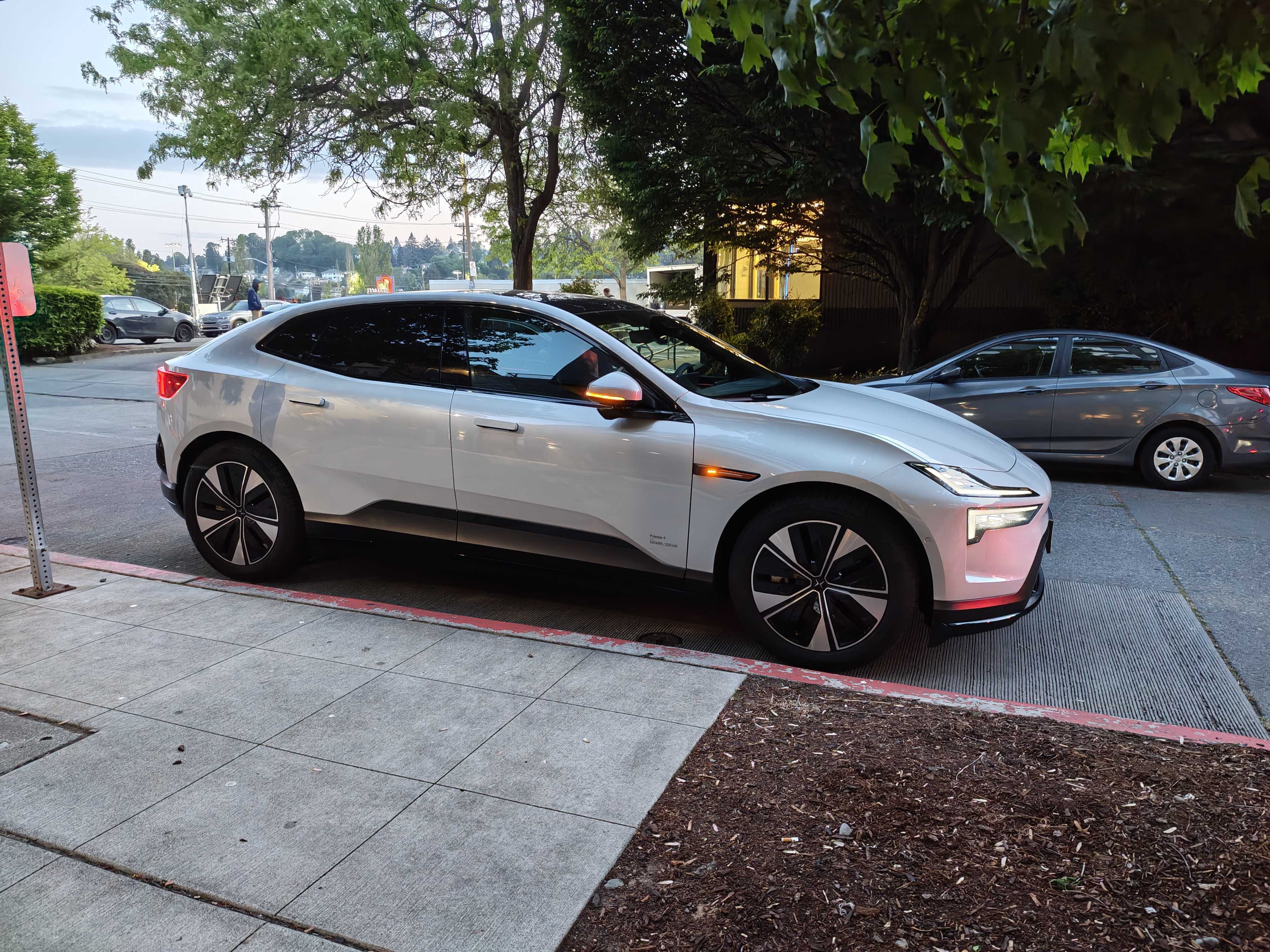 A Polestar 4 parked next to a sidewalk