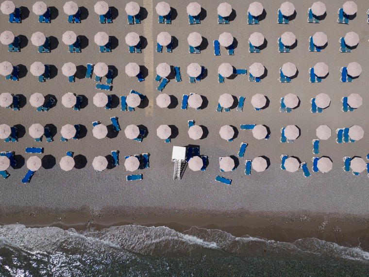 LARDOS, GREECE - JULY 29: In this aerial view empty sun loungers line the beach at a resort on July 29, 2023 in Lardos, Rhodes, Greece. Since the wildfires that swept across the south of the island over the last few days many of the tourist hotels have emptied with holiday makers returning to their respective countries, or finding alternative accommodation on other non affected parts of the island. While firefighting planes and helicopters are still dealing with sporadic outbreaks of wildfires on the island most of those are in the mountains and not a threat to people or property. The fires on Rhodes prompted preventive evacuations of tens of thousands of tourists in the middle of the high summer season last week. (Photo by Dan Kitwood/Getty Images)