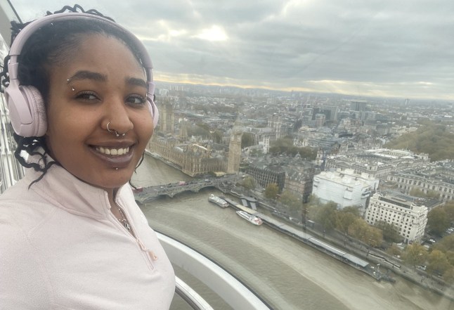 Tayler Laycy taking a selfie at the top of a very tall building in London, with a view of London in the backdrop (Picture: Tayler Laycy)
