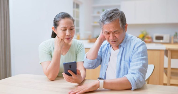 asian elderly couple use smartphone connected with smart watch to track health - they feel worried