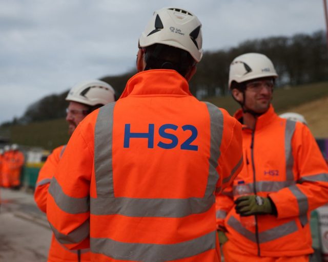 Construction workers and members of the media wait for tunnel boring machine 