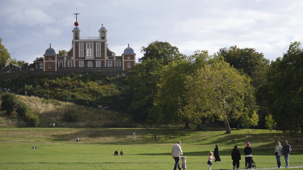 People walk in Greenwich Park in London, with the backdrop of the Royal Observatory, Monday, Sept. 22, 2025. (AP Photo/Joanna Chan)