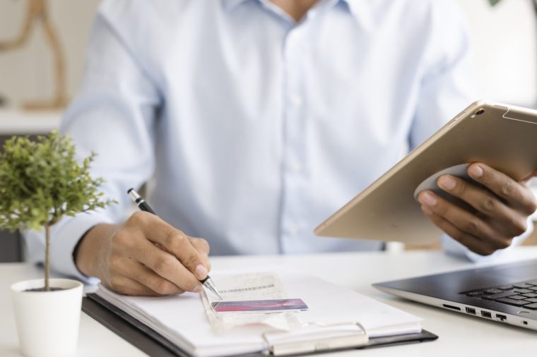 Close-up Businessman pays bills with digital tablet