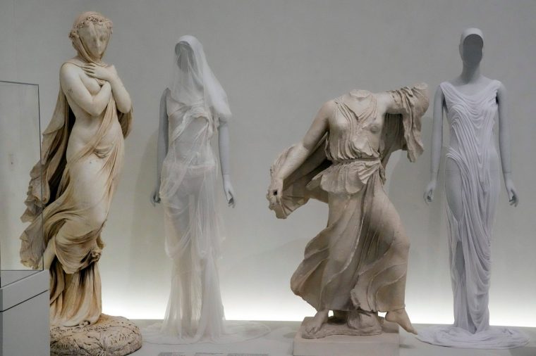 Fashion designs are displayed next to statues in the "Classical Body" section of the Metropolitan Museum of Art's Costume Institute exhibition, "Costume Art," on May 2, 2026, in New York. (Photo by Charles Sykes/Invision/AP)