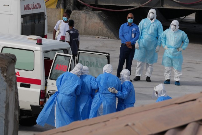FILE - Health workers in protective gear evacuate patients from the MV Hondius cruise ship into an ambulance at a port in Praia, Cape Verde, May 6, 2026. (AP Photo/Misper Apawu, File)