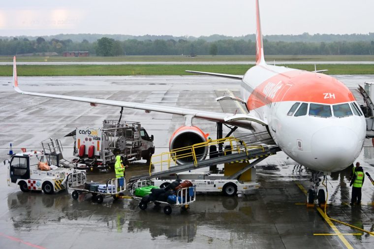 (FILES) A worker loads luggage onto an Easyjet aircraft as a fuel truck "CarbOil" services the plane at Milan's Malpensa Airport on April 13, 2026. The war in the Middle East and the closure of the Strait of Hormuz have caused a surge in aviation fuel prices and raised concerns about potential shortages this summer. On May 8, 2026, the EU Aviation Safety Agency (EASA) is expected to release recommendations on whether or not to use Jet A, a kerosene produced in the United States but not currently distributed in Europe for technical reasons. (Photo by Stefano Rellandini / AFP via Getty Images)