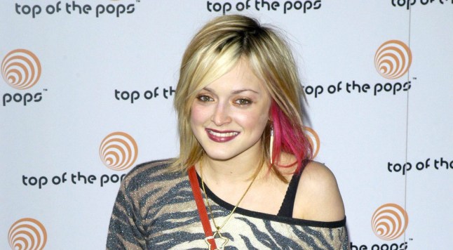 Fearne Cotton standing against a Top of the Pops backdrop, wearing a zebra print top, with pink and blonde died hair