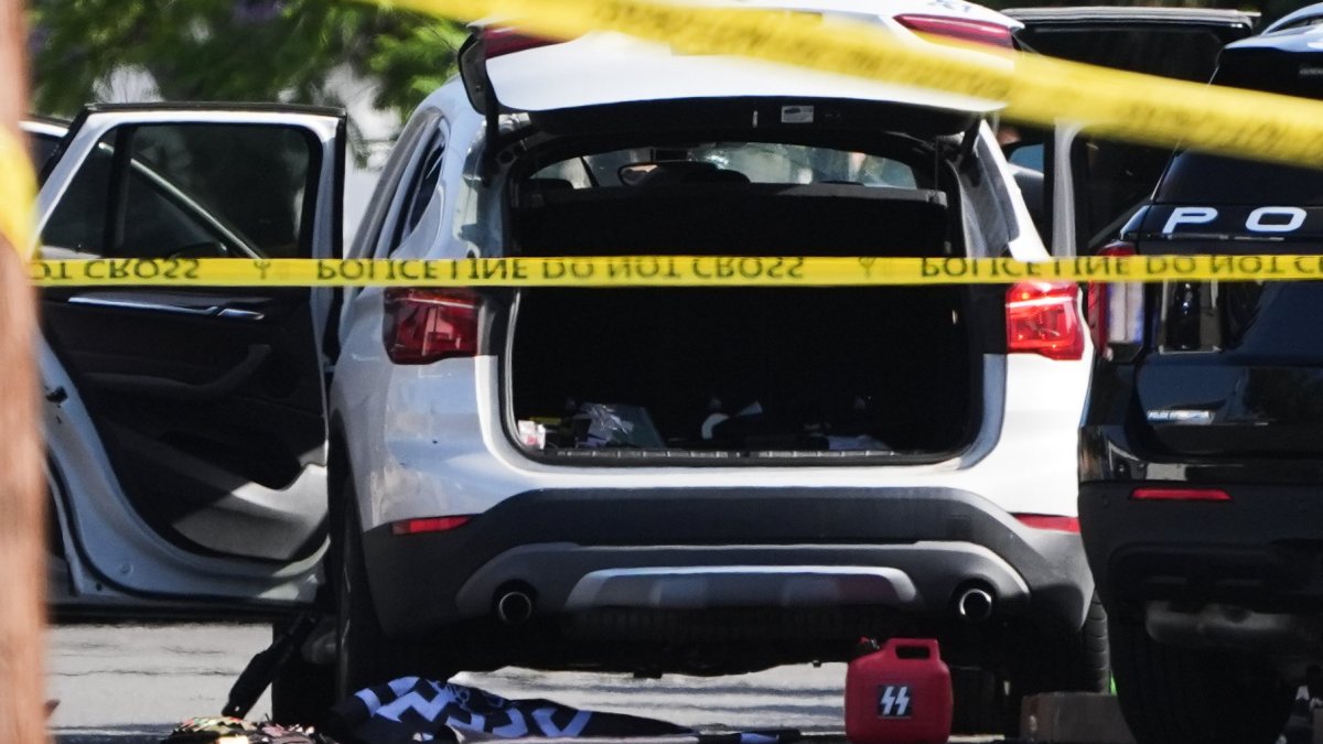 A vehicle's hatch and doors are opened near where a body of one of the shooters was placed near the scene of a shooting outside the Islamic Center of San Diego Monday, May 18, 2026, in San Diego. (AP Photo/Gregory Bull)