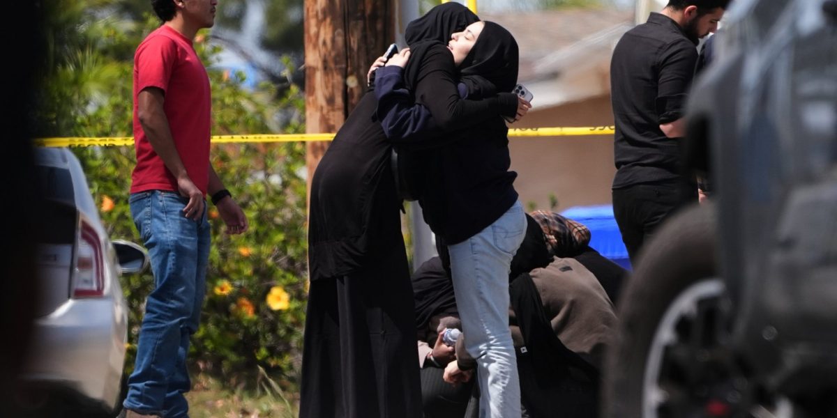 People embrace near the scene of a shooting outside the Islamic Center of San Diego Monday, May 18, 2026, in San Diego. (AP Photo/Gregory Bull)