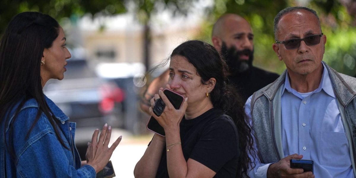 People stand behind police tape at the scene of a shooting outside the Islamic Center of San Diego Monday, May 18, 2026, in San Diego. (AP Photo/Gregory Bull)