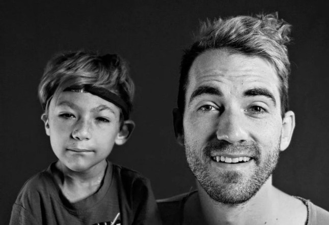 Daniel Coleman smiles in a black and white photo with his son Isaac.