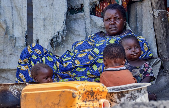 A family rests outside their tented shelter at the Kigonze camp for internally displaced persons, as authorities intensify efforts to contain an Ebola outbreak caused by the Bundibugyo virus in Bunia, Democratic Republic of Congo, May 25, 2026. REUTERS/Gradel Muyisa Mumbere