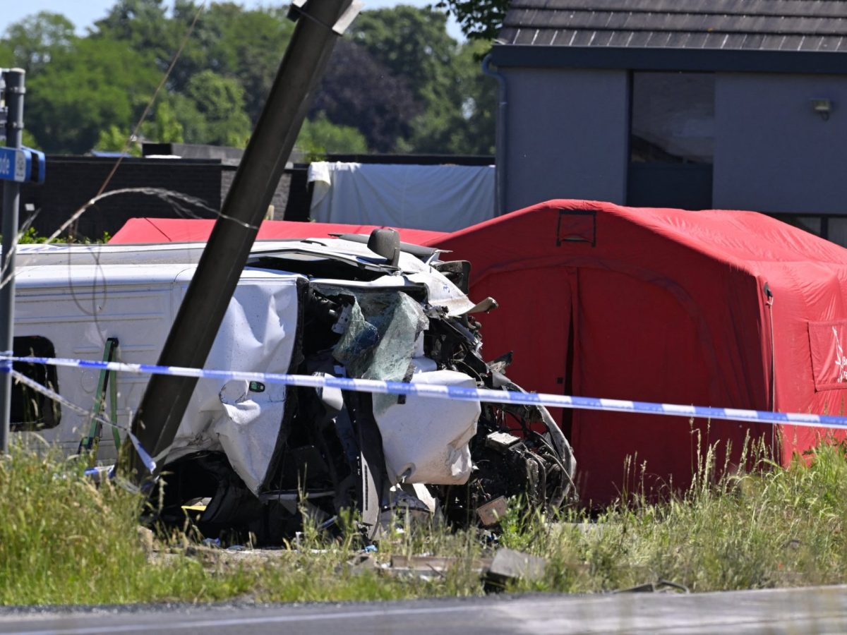 This photograph shows a damaged bus at the site of an accident after a train crashed into a school bus, at the railway crossing Vierhuizen in Buggenhout, some 20kms north of Brussels on May 26, 2026. Four people, including two children were killed when a train hit a school minibus in northern Belgium, the country's deputy prime minister said. (Photo by JOHN THYS / AFP via Getty Images)