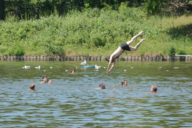 A person jumping into a pond in Hampstead Heath, London, during the UK heatwave. (Picture: W8media)