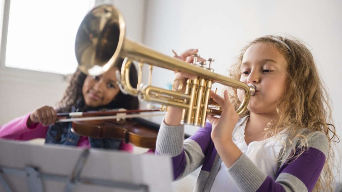 Girls practicing playing violin and trumpet