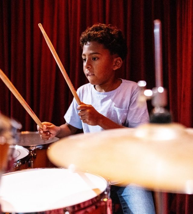 Boy playing drums in a music school
