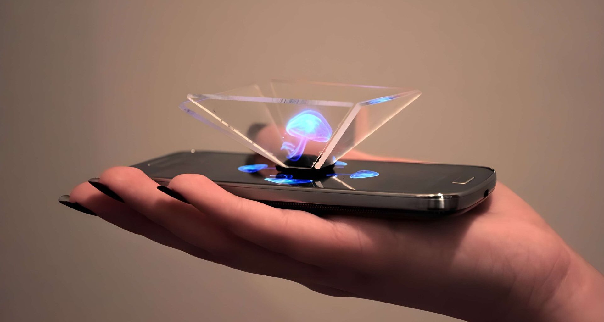 A hand holding an unbranded smartphone projecting a blue hologram using a transparent pyramid device.