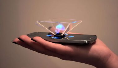 A hand holding an unbranded smartphone projecting a blue hologram using a transparent pyramid device.