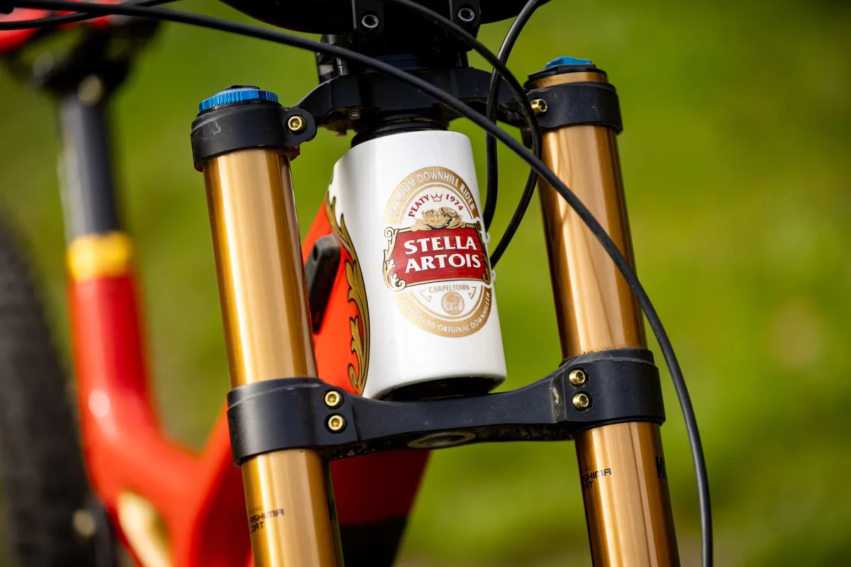 Close-up of the head tube on Steve Peat’s Santa Cruz V10 Stella bike, showing a custom Stella Artois-style head badge between Fox 40 fork stanchions.