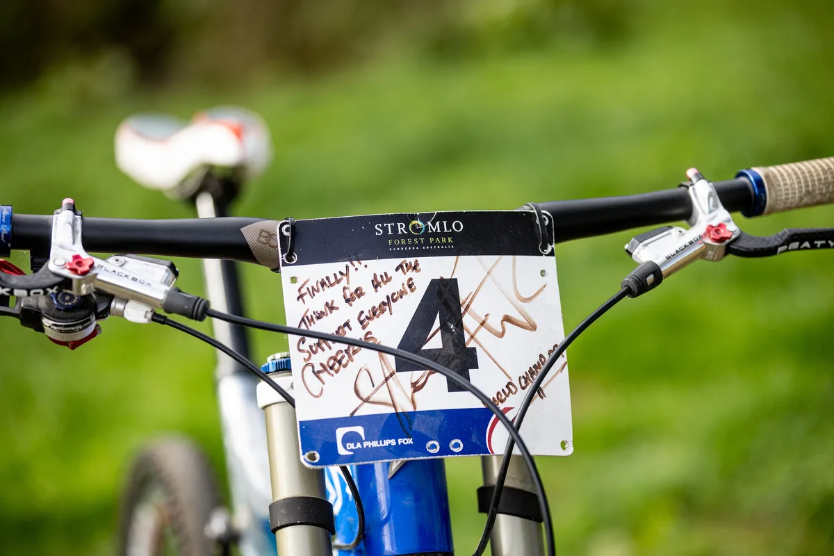 Close-up of Steve Peat’s Santa Cruz V10 cockpit with a signed Stromlo Forest Park number board from the 2009 World Championships.