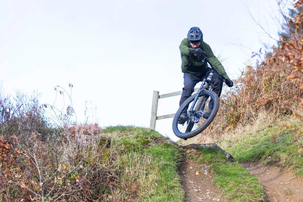 Whyte Secta S hardtail mountain bike being jumped off a drop on a trail centre descent.