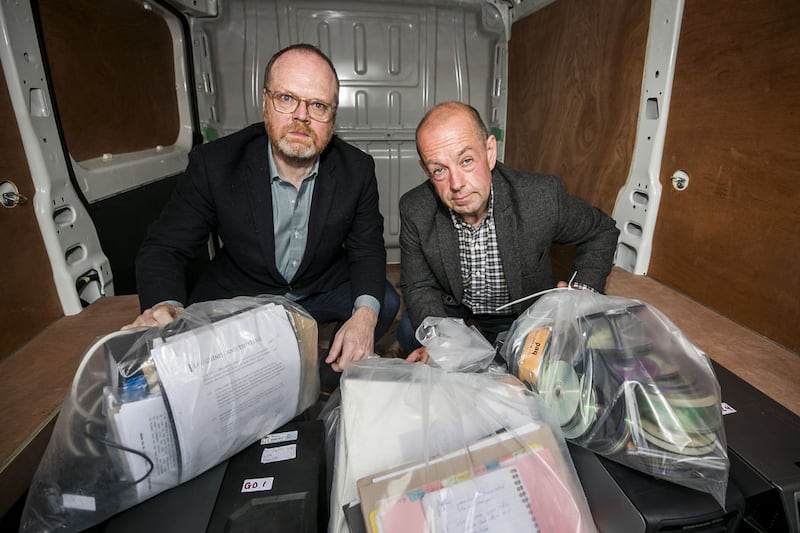 Investigative journalists Trevor Birney (left), and Barry McCaffrey outside Castlereagh Police Station in Belfast, with a haul of journalistic material unlawfully seized by police following the making of the Loughinisland documentary No Stone Unturned 