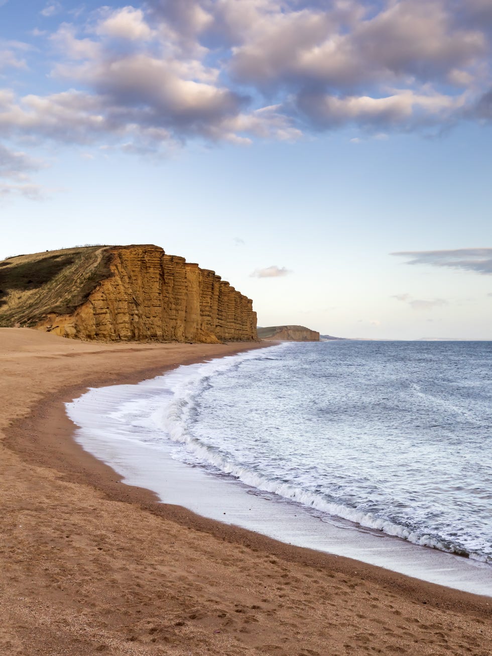 coastal landscape featuring cliffs and a sandy beach coastal landscape featuring cliffs and a sandy beach