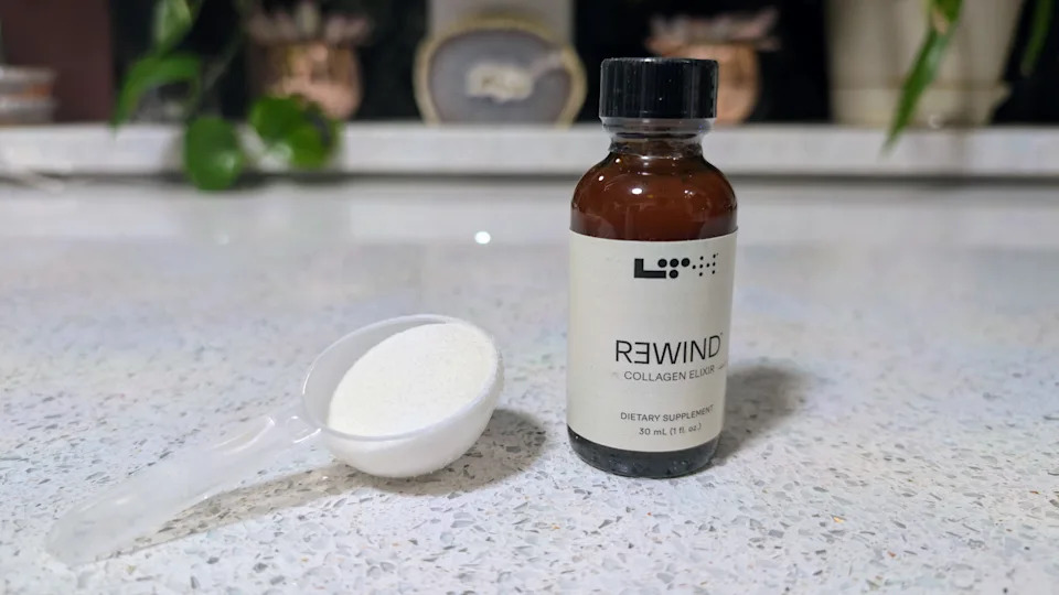 A bottle of LTH Rewind Collagen Elixir next to a scoop of powdered collagen supplement.