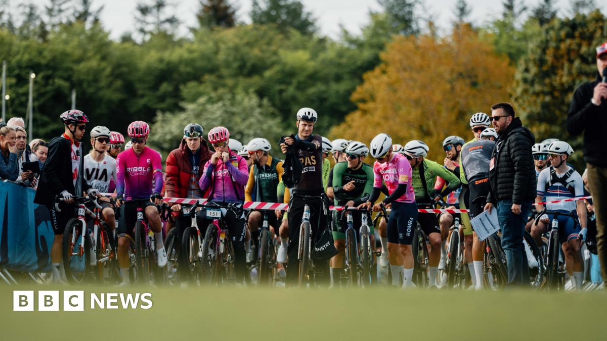 A line up of cyclists in bright lycra at a starting line-up