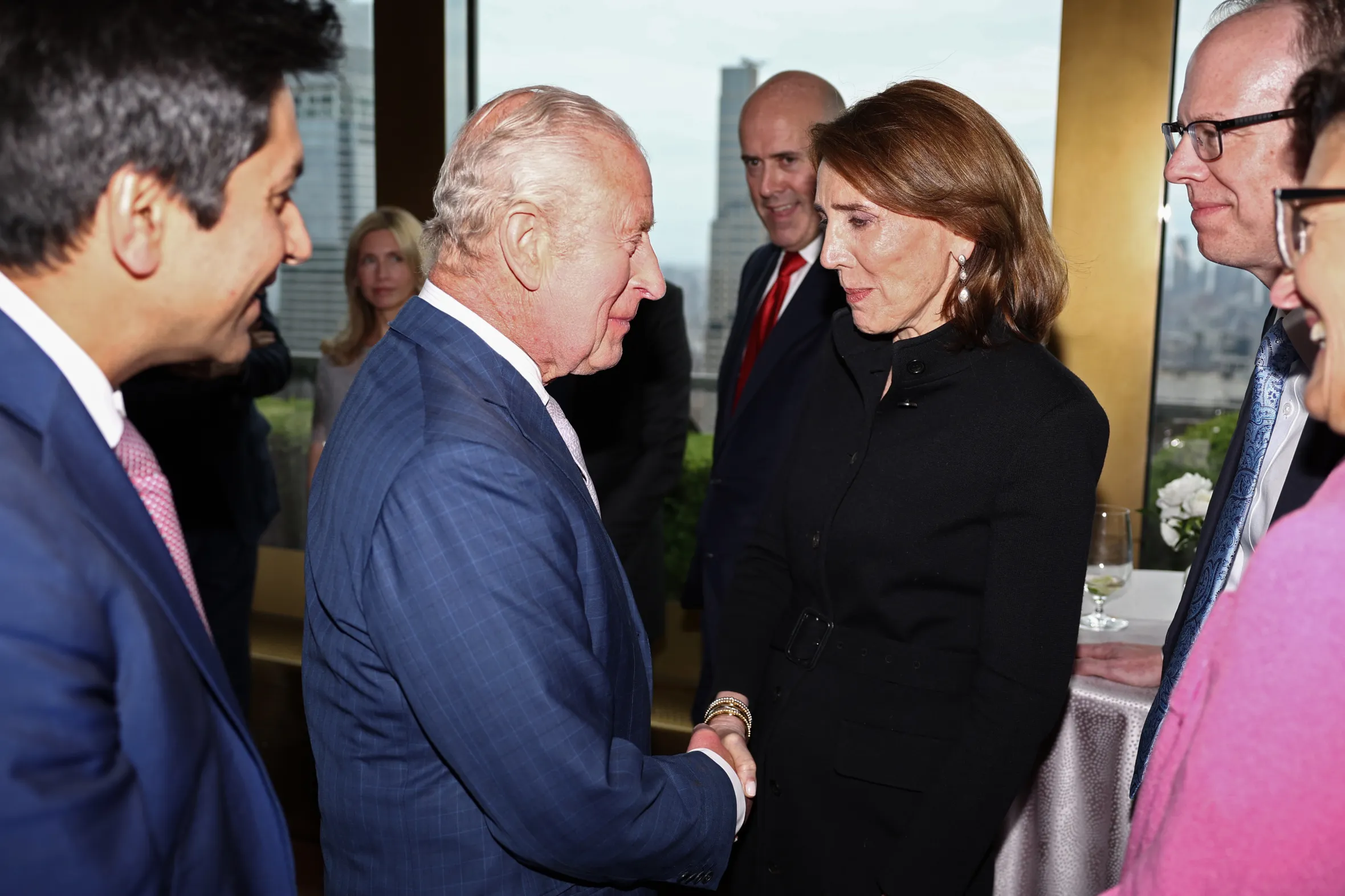 King Charles III shakes hands with Ruth Porat, President and Chief Investment Officer of Google, at a UK-U.S. trade event.