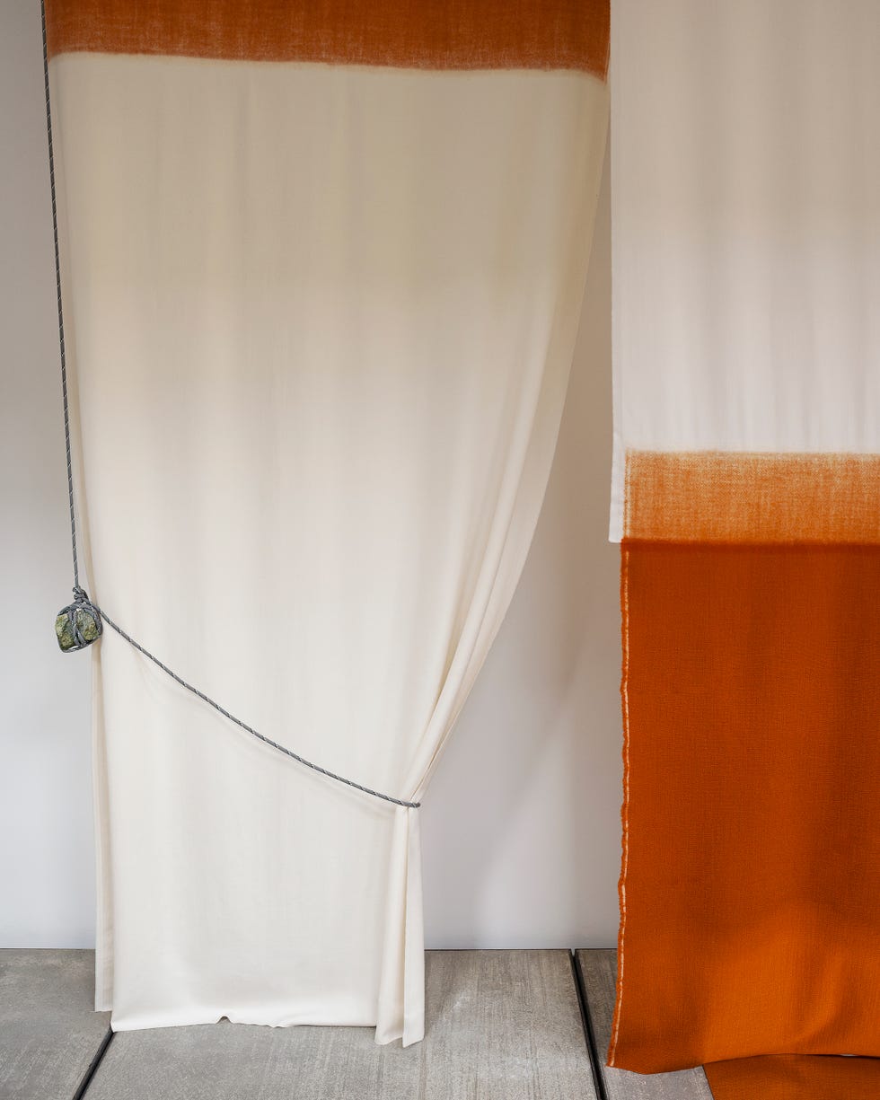 Textile panels in neutral and orange tones.
