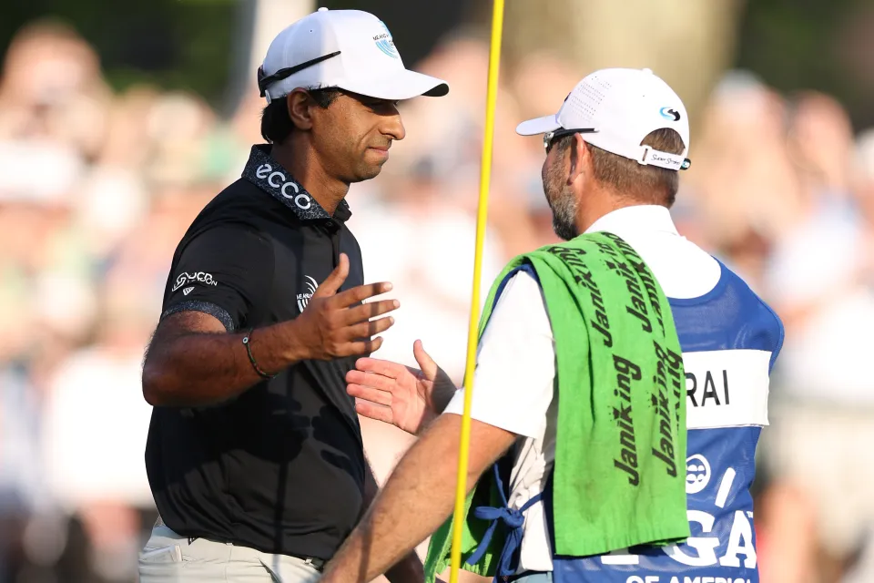 Aaron Rai of England and caddie Jason Timmis shake hands on the 18th green during the final round of the PGA Championship at Aronimink Golf Club on May 17, 2026