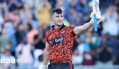 Jordan Hermann holding his bat in the air while standing on the pitch during a match for Surisers Eastern Cape