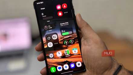 Man's hand holding a Samsung Galaxy phone showing the Home screen